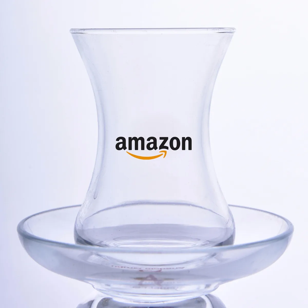 Slender-waisted tea glass with black text and orange arrow logo — Model 1002c